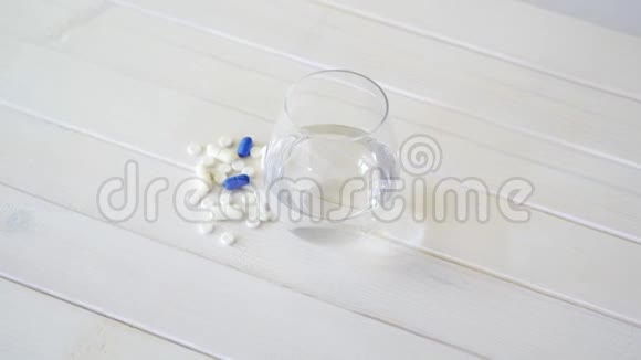 白色木桌上的水晶水和一套药丸视频的预览图