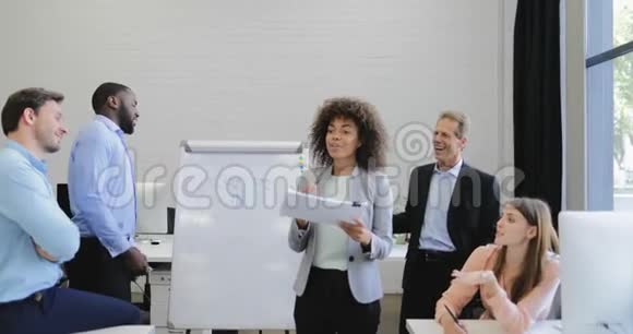 女企业家在会议室的会议上领导演讲商务人士小组听取同事的报告视频的预览图