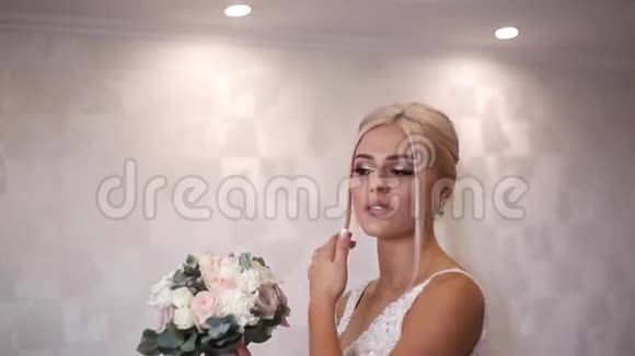 优雅的新娘手里拿着一束婚礼花束漂亮的金发女孩有时尚的妆容和发型妇女模式视频的预览图