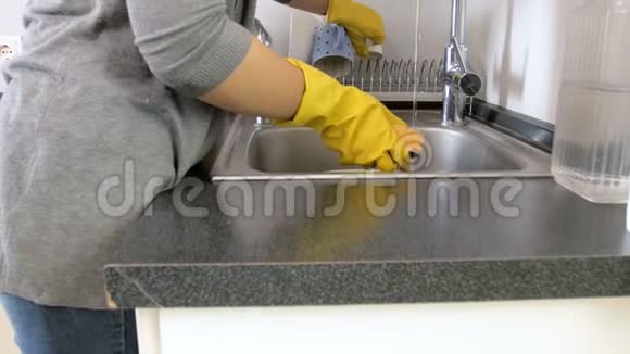 4K淘盘视频穿黄色阿尔特丝手套的年轻女子在厨房洗碗视频的预览图
