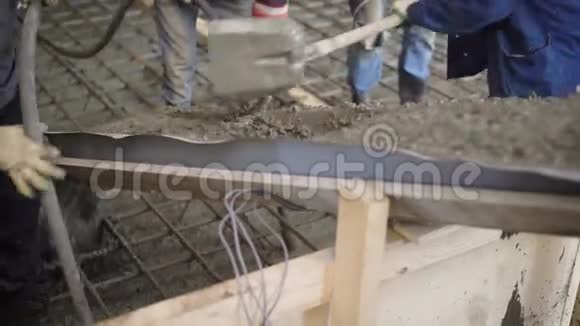 工人们正在用混凝土泵在钢筋笼上铺设混凝土拌合物以便在建筑物的地板上铺设混凝土视频的预览图
