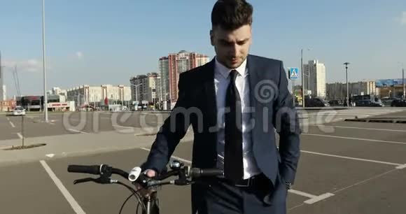 一个穿着蓝色西装的商人走在城市街道上手里拿着一辆自行车视频的预览图
