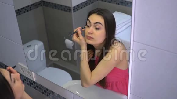 漂亮的女孩在浴室化妆用铅笔染眼睛视频的预览图