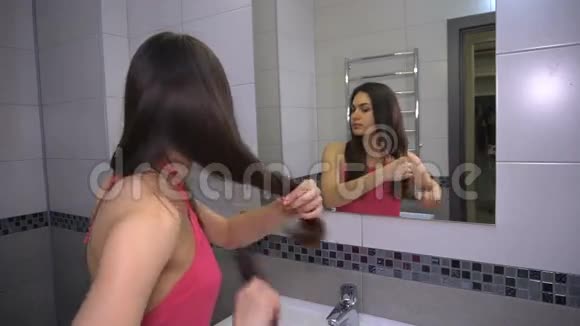 女孩站在镜子前梳头视频的预览图