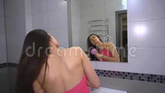 黑发女郎在站在镜子前的浴室里做发型视频的预览图