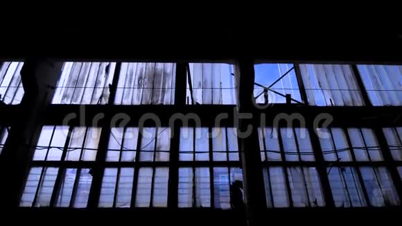 有许多窗户的老空建筑的大玻璃墙照相机正在黑暗的空间中移动视频的预览图
