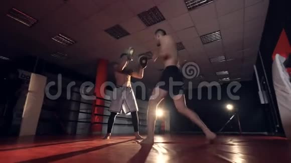 拳击手正用胳膊和腿打教练MMA训练视频的预览图