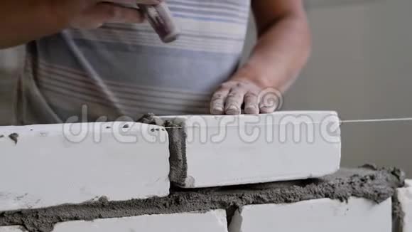建筑工人正在做砌砖工作用子把砖打平然后取出多余的水泥砂浆视频的预览图