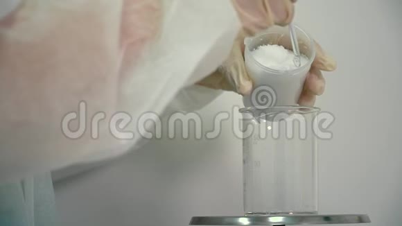 实验室用电子秤测量粉末重量的化验师视频的预览图