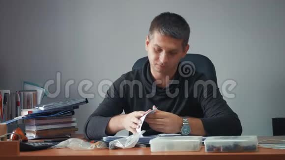 快乐的年轻商人坐在办公室桌上有商业文件帅哥在工作在家写字视频的预览图