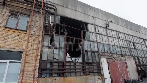 阴天拆除旧工业建筑立面玻璃破碎框架破坏视频的预览图