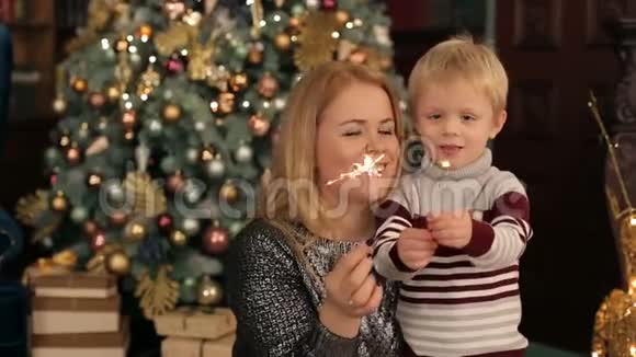 妈妈和孩子在圣诞树附近闪闪发光视频的预览图