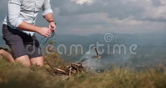 孤独在山里人在山顶上准备篝火后面有很大的山景视频的预览图