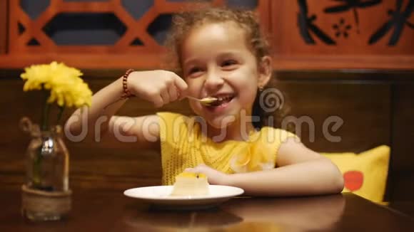 快乐的孩子在咖啡馆里吃奶酪蛋糕视频的预览图