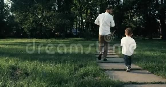 父亲带着儿子在公园慢跑慢动作4k视频的预览图