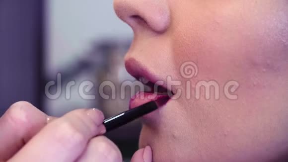 化妆师在嘴唇上涂粉红色唇膏视频的预览图