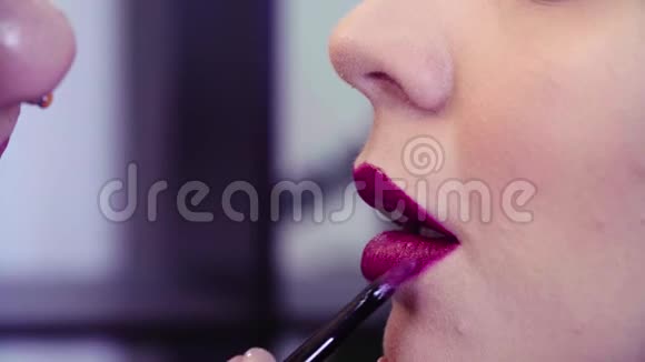 化妆师在嘴唇上涂粉红色唇膏视频的预览图