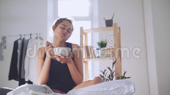年轻女士在床上慢动作吃早餐早晨和睡眠的概念视频的预览图
