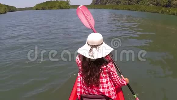 女子划艇在美丽的泻湖动作镜头女孩坐在皮划艇视频的预览图