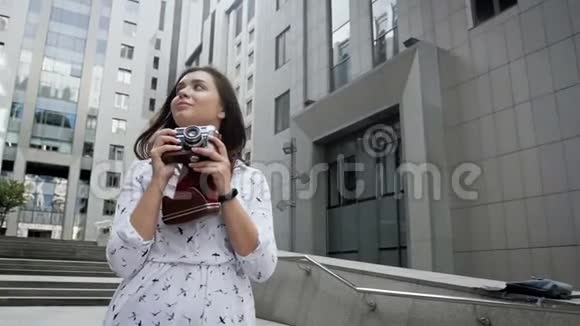 带长发的快乐微笑女孩用相机拍照的慢镜头视频视频的预览图