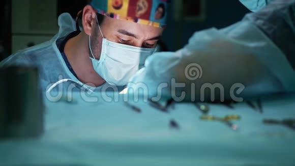 关闭手术病人的外科医生工作中外科医生的肖像戴着医用面具视频的预览图
