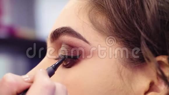 化妆师在眼睛上画黑色眼线视频的预览图