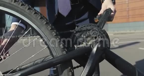 一位年轻的商人试图修理一辆倒自行车视频的预览图