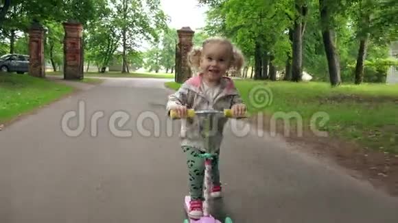 夏天小孩子在公园里骑滑板车可爱的女孩在户外玩耍视频的预览图