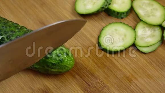 在木板上切鲜绿黄瓜用刀煮切菜切成两半视频的预览图