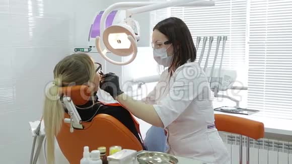 牙医检查年轻女子牙齿特写视频的预览图