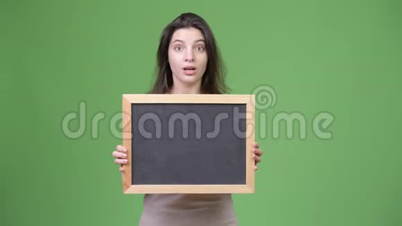 年轻的美女拿着黑板看着惊讶视频的预览图