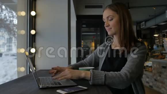 女人在咖啡馆里打手提电脑视频的预览图