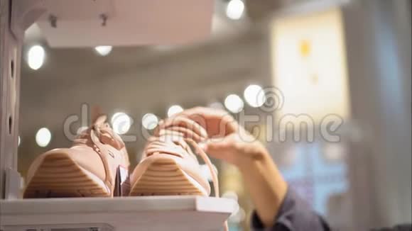 一位年轻的时髦女性在商店里选择新运动鞋购物视频的预览图