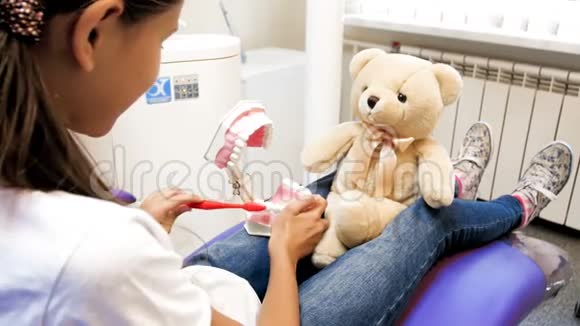 4k视频女孩病人坐在牙医椅上玩玩具熊视频的预览图