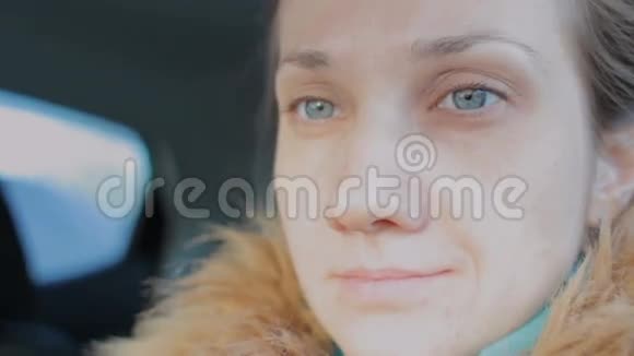 特写坐在车里的年轻漂亮女人的肖像有着明亮蓝眼睛的女孩视频的预览图