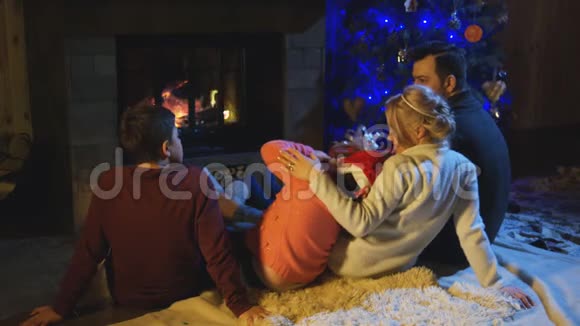 家庭在圣诞节的壁炉里度过时光视频的预览图