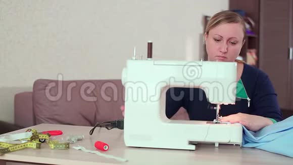 一个裁缝在家里的桌子上工作与一台白色缝纫机她创造了新衣服视频的预览图