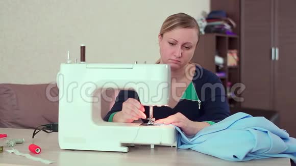 一个裁缝在家里的桌子上工作与一台白色缝纫机她创造了新衣服视频的预览图