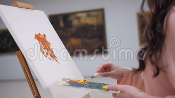 女人画一幅画在画布上涂上油漆视频的预览图