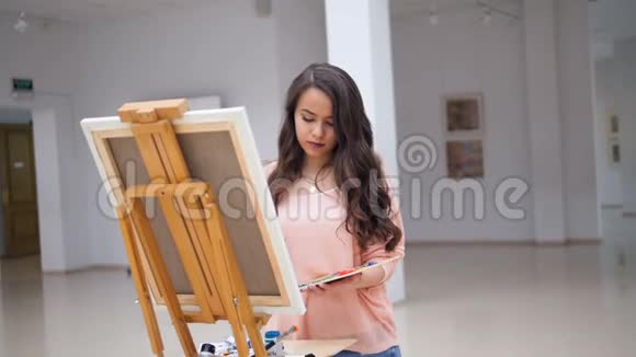 漂亮的女孩拿着画笔画着一幅画视频的预览图