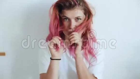漂亮的女人玩粉红色的头发视频的预览图