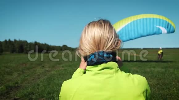 女孩和主动头盔金发女孩戴着头盔保护头部会在滑翔伞上飞行视频的预览图