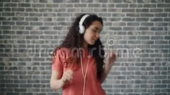 戴耳机跳舞听音乐欣赏歌曲的快乐女人的肖像视频的预览图