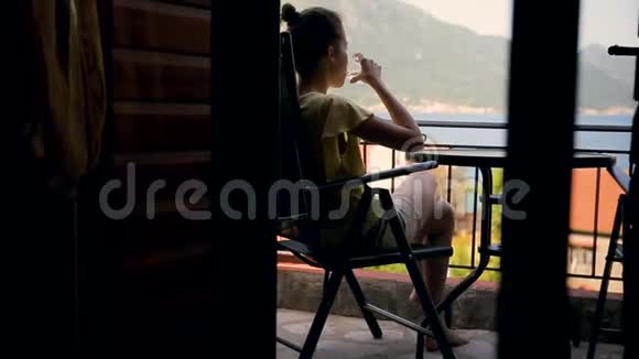 健康的年轻女性从玻璃中喝淡水女士在豪华酒店露台放松时喝水健康视频的预览图