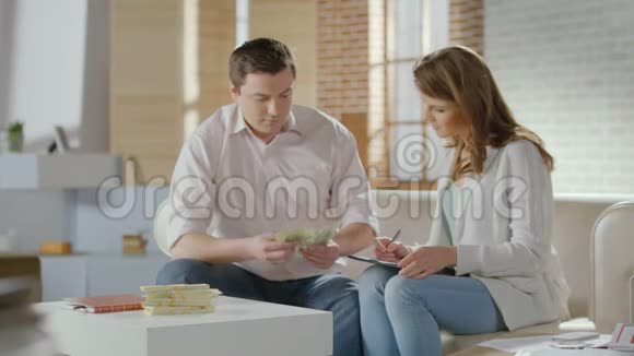 丈夫数着钱告诉妻子好消息富有的家庭视频的预览图