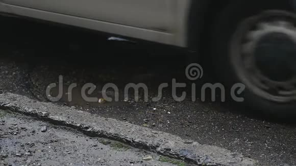 车撞到两个锅洞汽车在两个充满水的坑洞中缓慢行驶视频的预览图