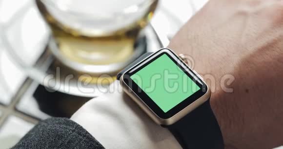 关闭商务人员手与智能手表绿色屏幕色度键背景舒适的咖啡馆视频的预览图