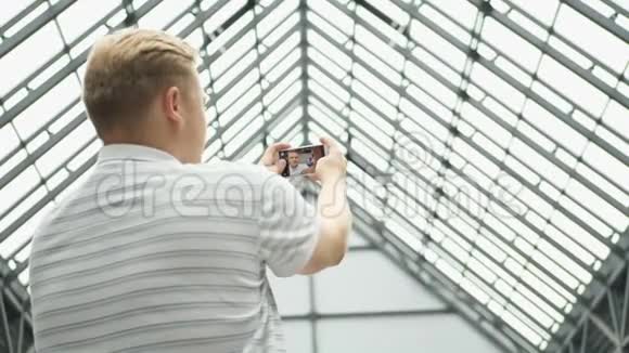 年轻人在智能手机上视频聊天帅哥自拍使用智能手机拍照的情侣视频的预览图