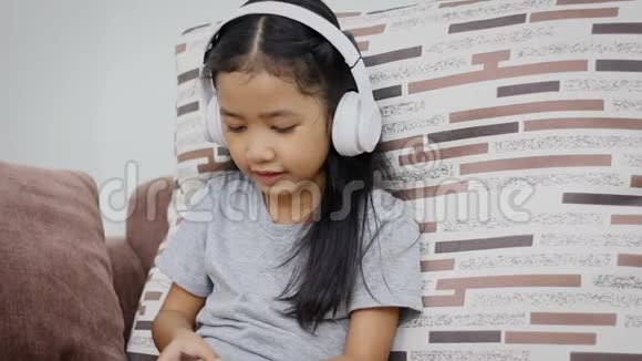 亚洲小女孩使用白色无线耳机快乐视频的预览图