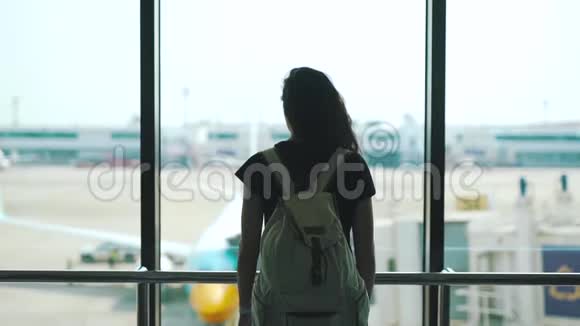 站在机场休息室窗口的女孩视频的预览图